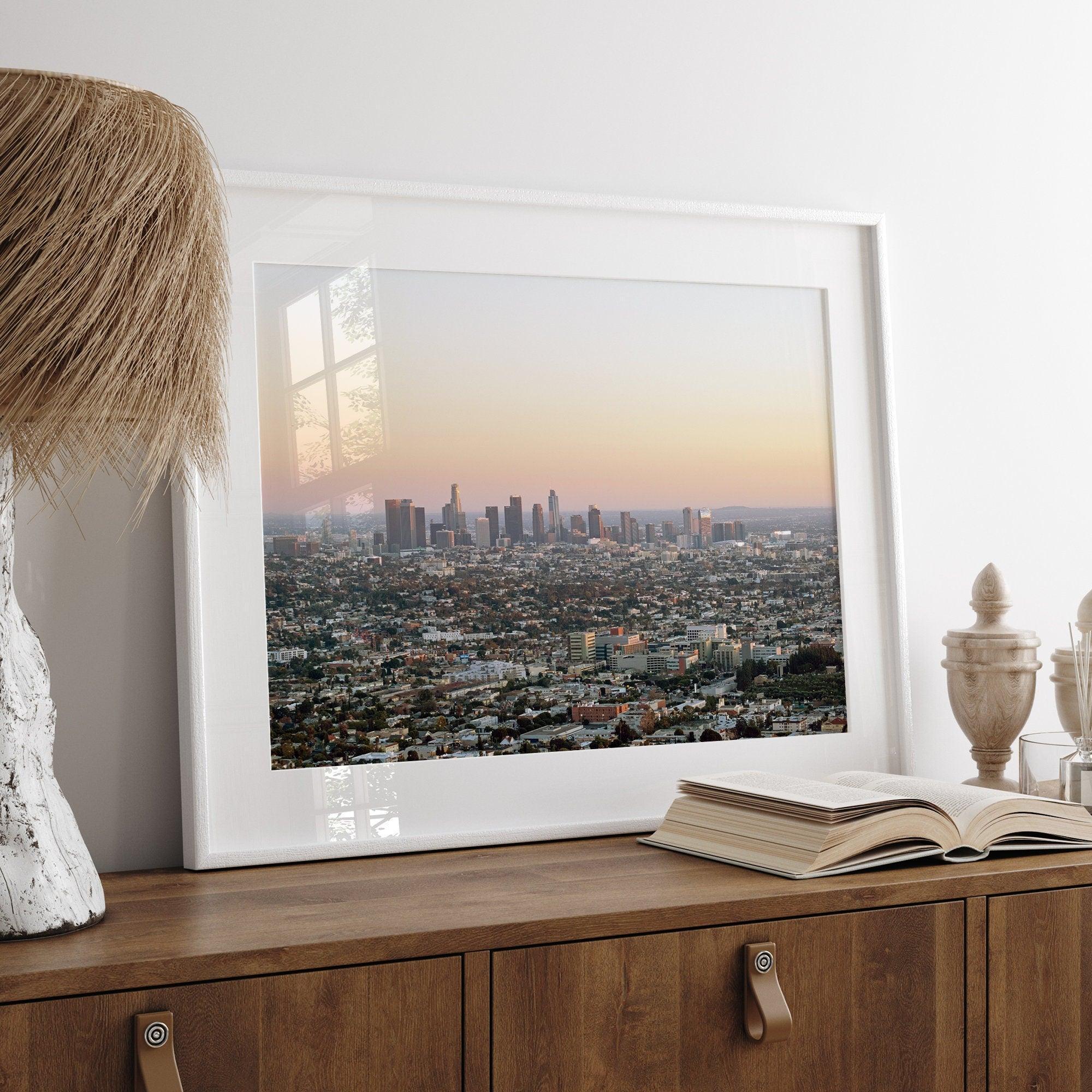 Los Angeles cityscape bathed in a vibrant sunset, showcasing the city's iconic buildings from above