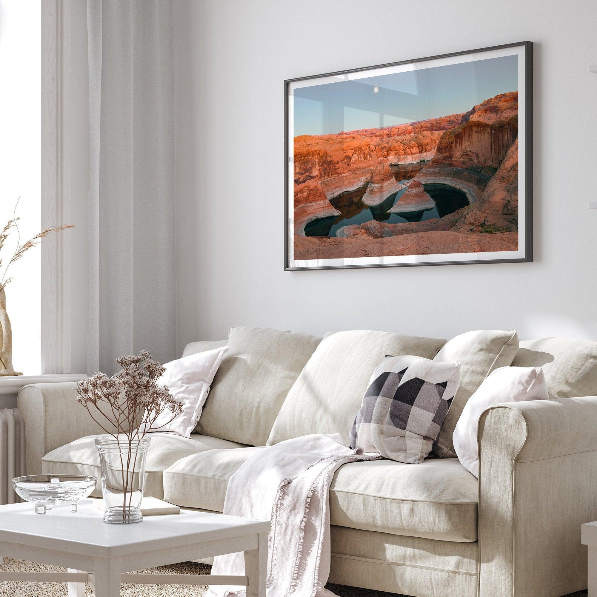 Landscape photo of Reflection Canyon in the Utah desert at sunset, with fiery red hues reflected in still water below a blue sky with a moon.