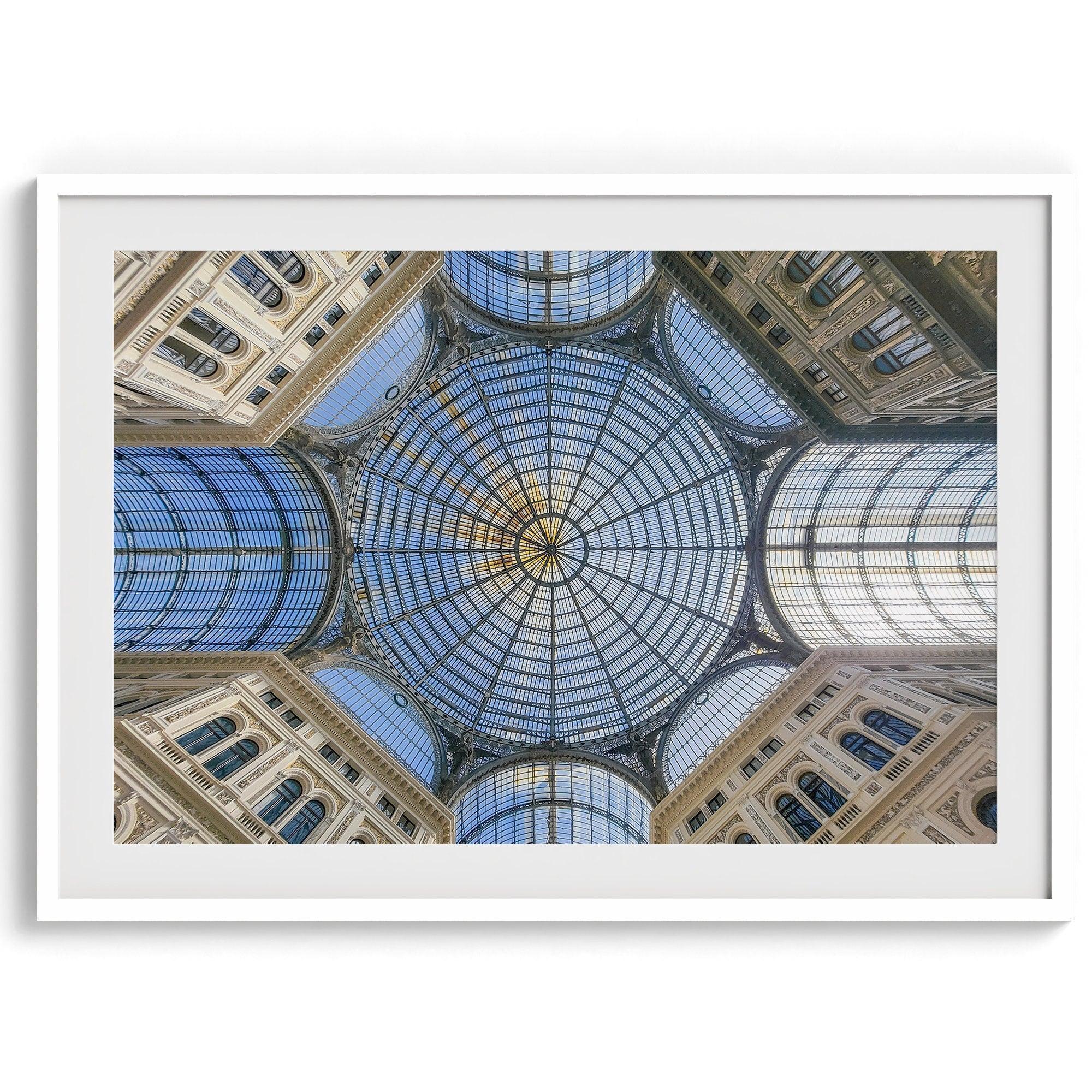 Framed fine art print featuring a symmetrical view of the glass and steel roof of the Galleria Umberto I, a historic building in Naples, Italy. The intricate geometric patterns create an abstract composition.