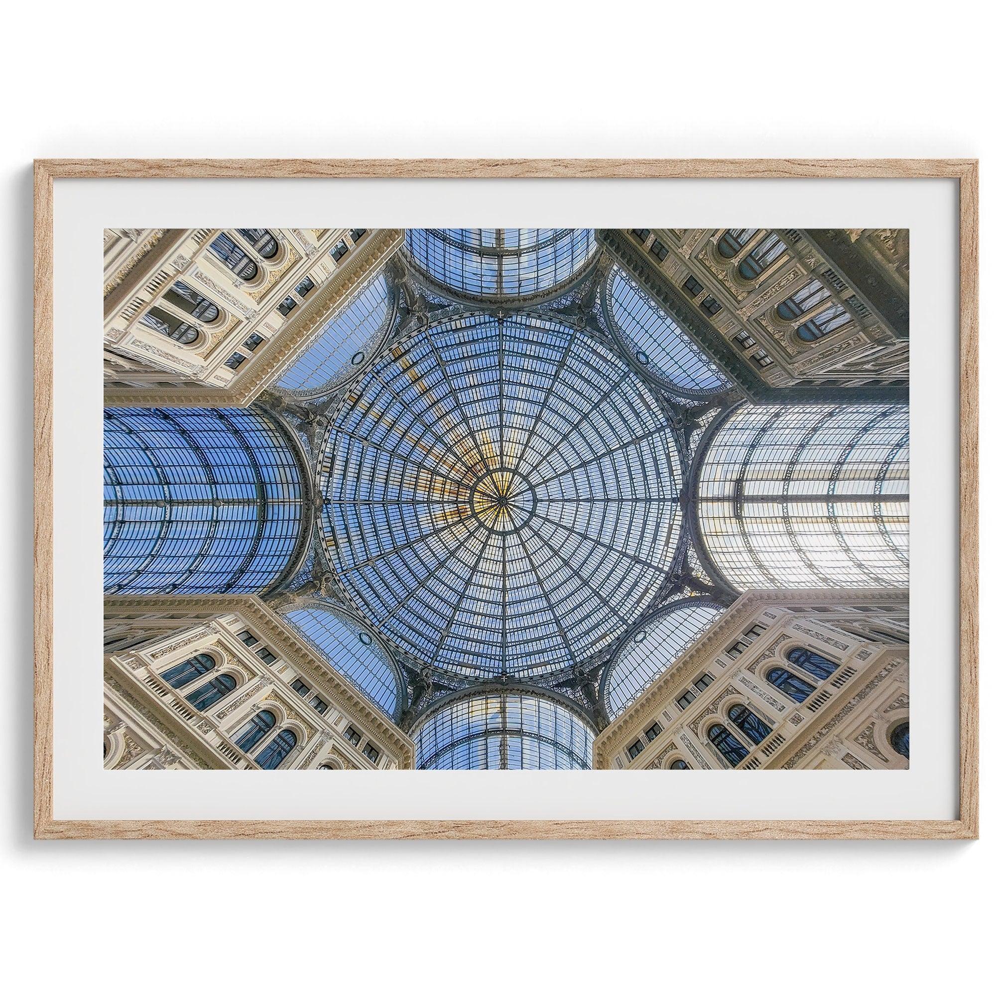 Framed fine art print featuring a symmetrical view of the glass and steel roof of the Galleria Umberto I, a historic building in Naples, Italy. The intricate geometric patterns create an abstract composition.