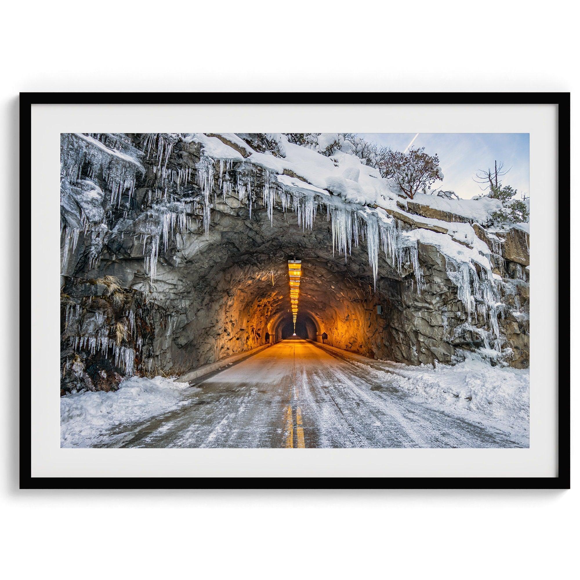 A fine art mountain photography print showing a Yosemite National Park winter scene: A mysterious snow-covered tunnel with an orange glow beckons visitors deeper into the park.