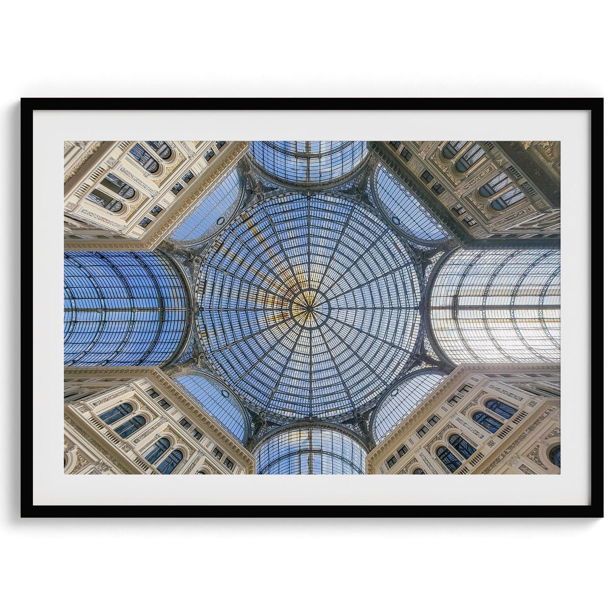 Framed fine art print featuring a symmetrical view of the glass and steel roof of the Galleria Umberto I, a historic building in Naples, Italy. The intricate geometric patterns create an abstract composition.