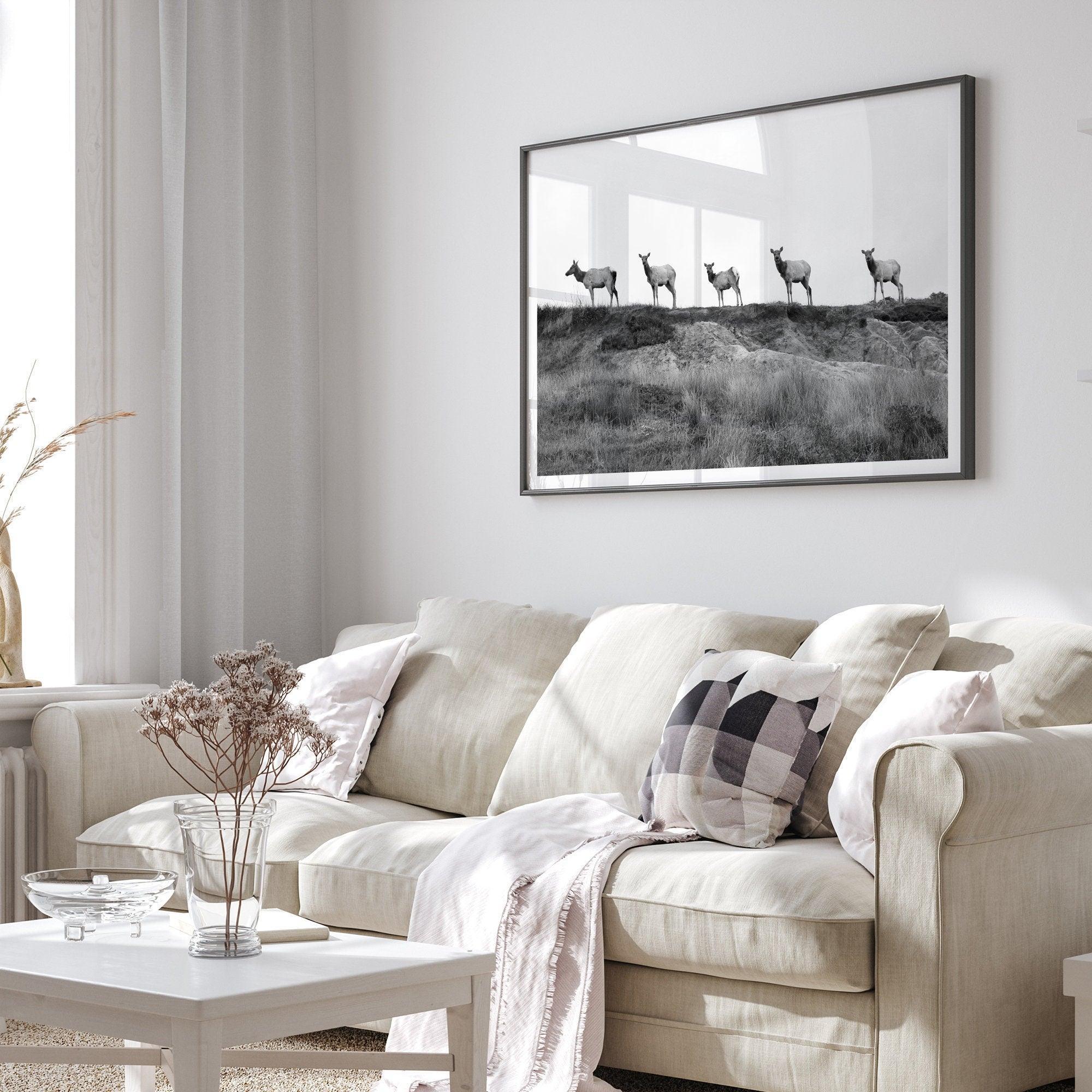 A black and white framed or unframed nature fine art photography print showing a family of coastal elks walking in a line on a ridge in Point Reyes, California. The composition forms a minimalist aesthetic print that will be a conversation starter.