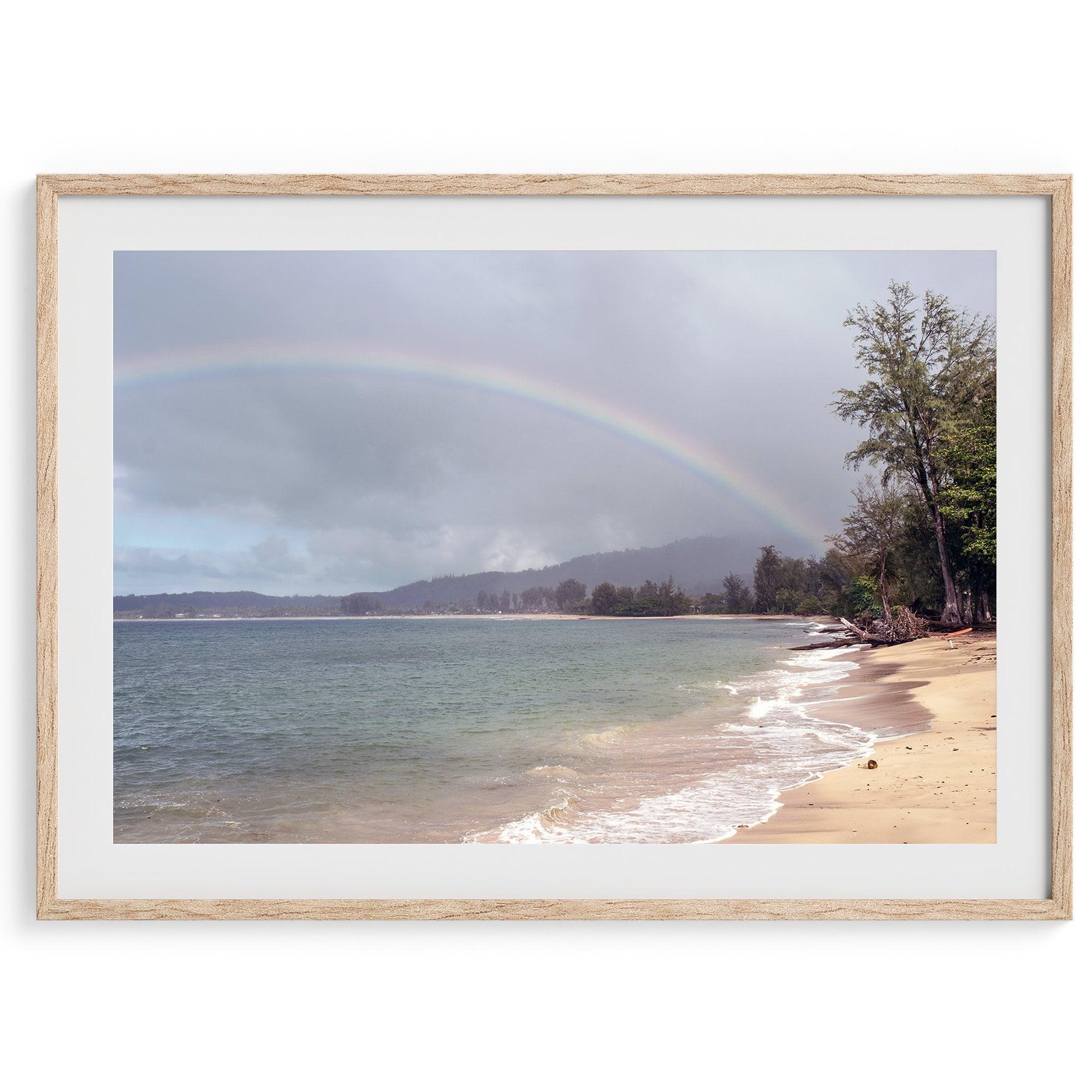 A framed or unframed beach fine art photography print showcasing a stunning tropical beach in Kauai, Hawai with a large breathtaking rainbow across it.