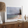 A framed or unframed beach fine art photography print showcasing a stunning tropical beach in Kauai, Hawai with a large breathtaking rainbow across it.