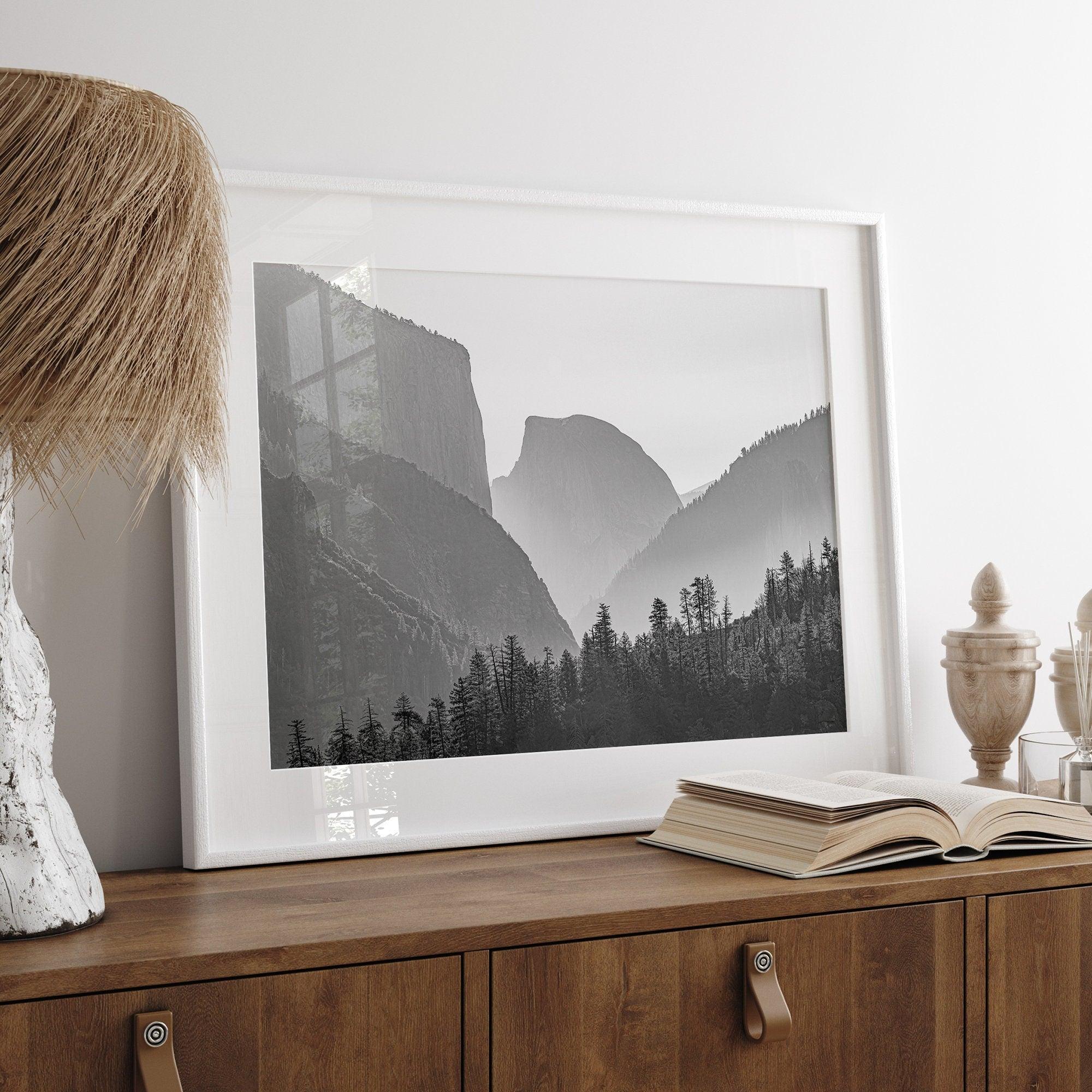 A black and white photography wall art of Yosemite Valley at sunset, featuring the iconic Half Dome and El Capitan bathed in dramatic light and shadow. Perfect for nature lovers and art enthusiasts.