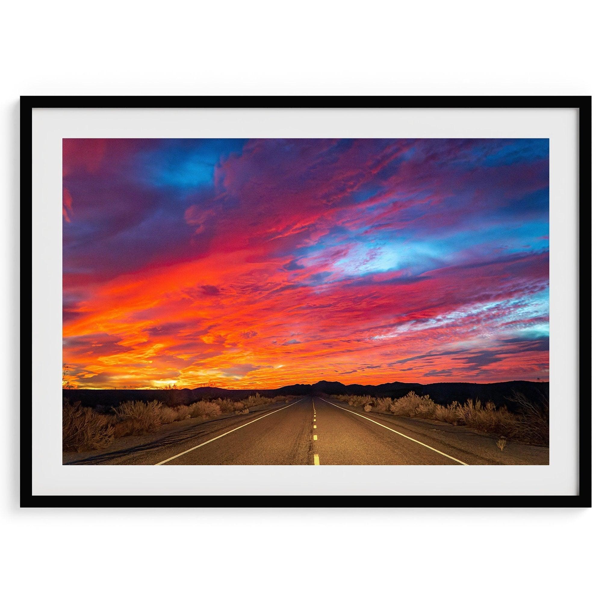 Mojave Desert Sunset Print - A captivating wall art featuring vibrant hues of a late desert sunset casting a warm glow over a timeless desert road. Perfect for desert enthusiasts and nature lovers."