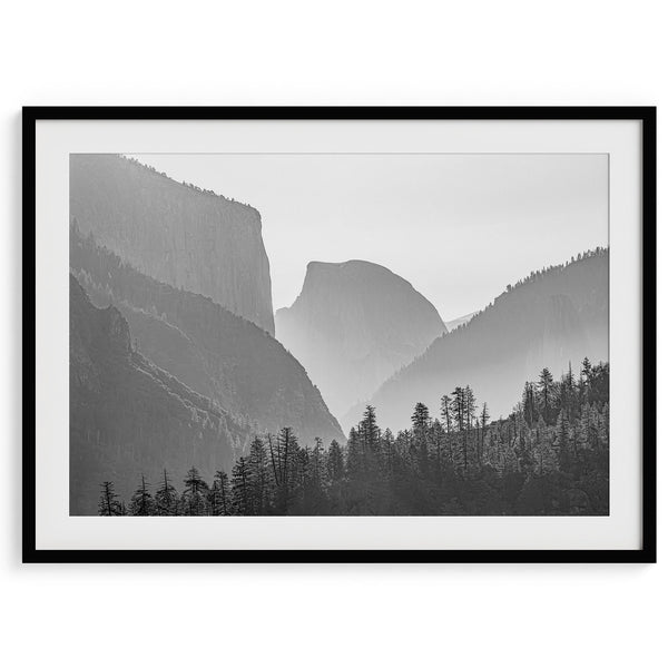 A black and white photography wall art of Yosemite Valley at sunset, featuring the iconic Half Dome and El Capitan bathed in dramatic light and shadow. Perfect for nature lovers and art enthusiasts.