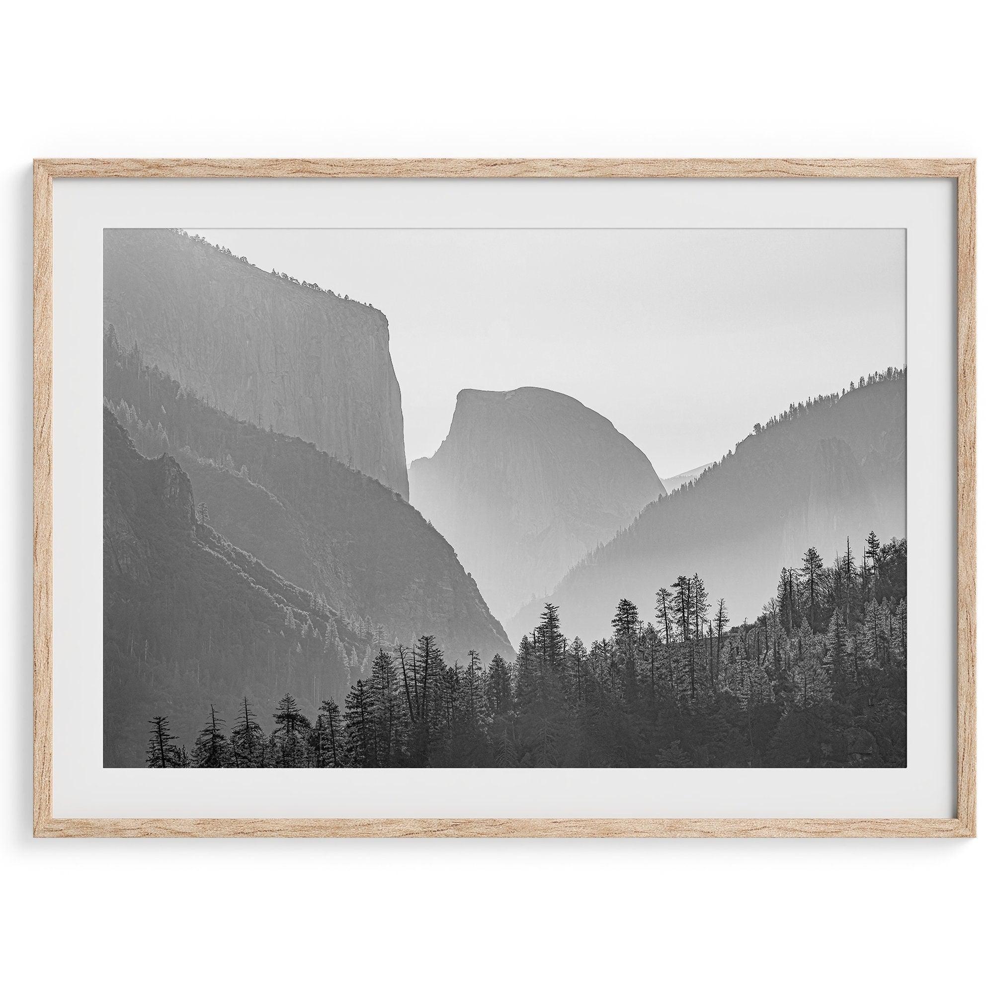 A black and white photography wall art of Yosemite Valley at sunset, featuring the iconic Half Dome and El Capitan bathed in dramatic light and shadow. Perfect for nature lovers and art enthusiasts.