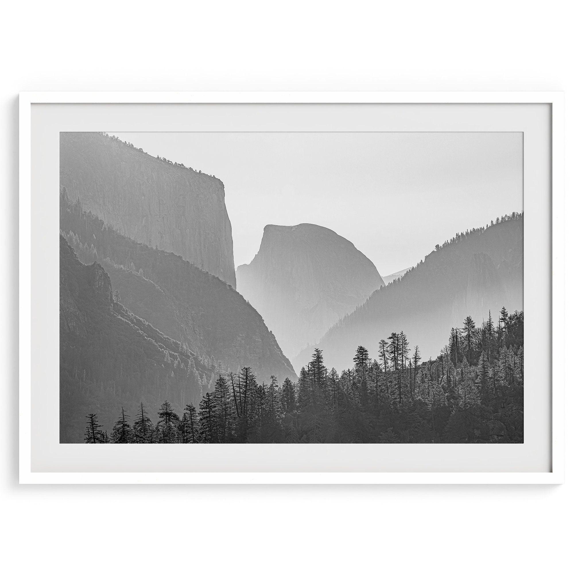 A black and white photography wall art of Yosemite Valley at sunset, featuring the iconic Half Dome and El Capitan bathed in dramatic light and shadow. Perfect for nature lovers and art enthusiasts.