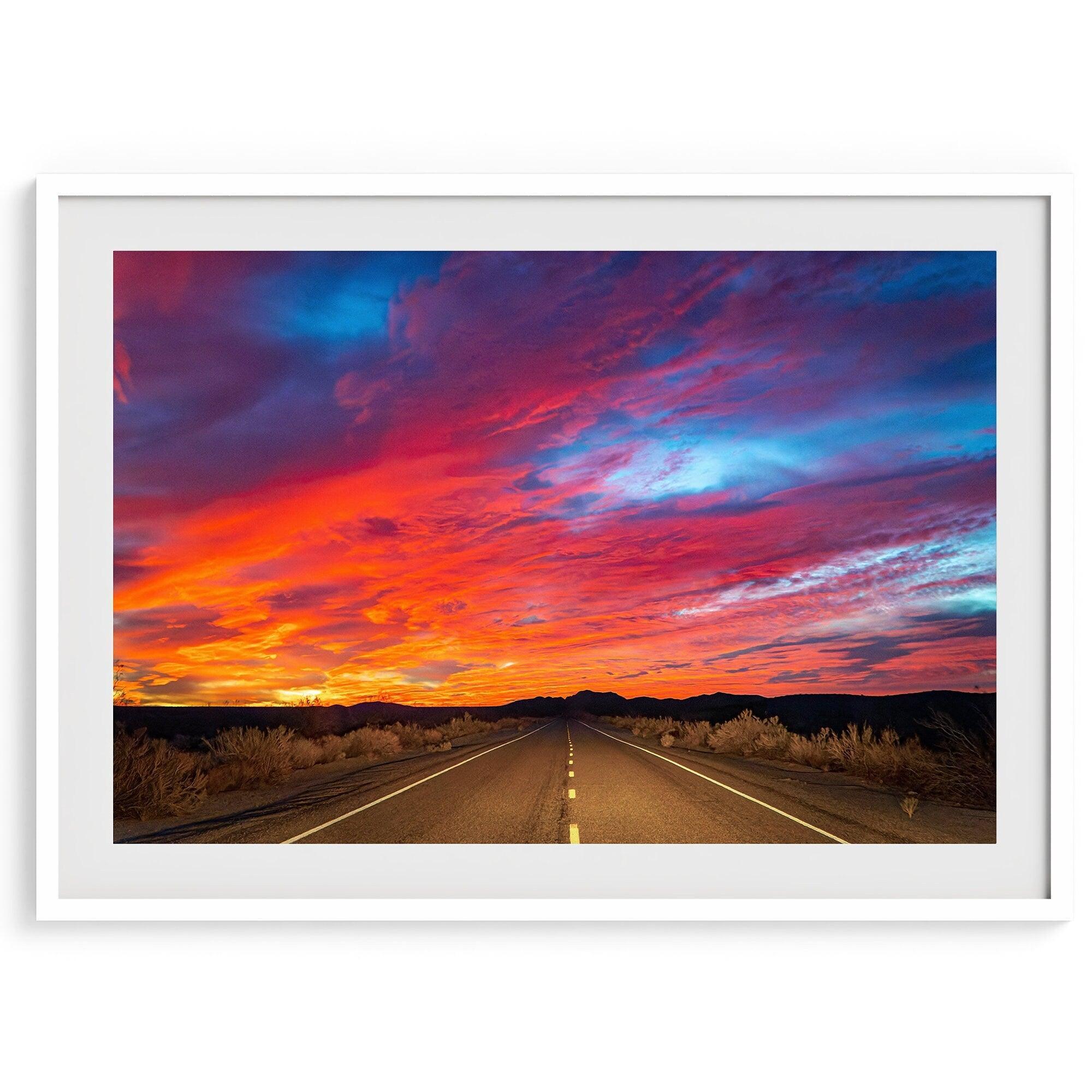 Mojave Desert Sunset Print - A captivating wall art featuring vibrant hues of a late desert sunset casting a warm glow over a timeless desert road. Perfect for desert enthusiasts and nature lovers."