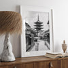 Timeless Kyoto scene with traditional architecture and kimono-clad woman in black and white.