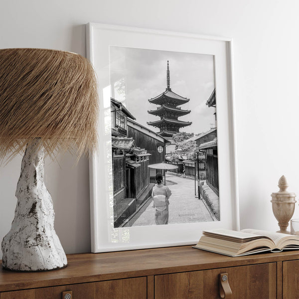 Timeless Kyoto scene with traditional architecture and kimono-clad woman in black and white.
