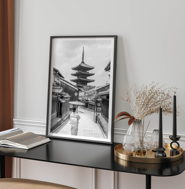 Timeless Kyoto scene with traditional architecture and kimono-clad woman in black and white.