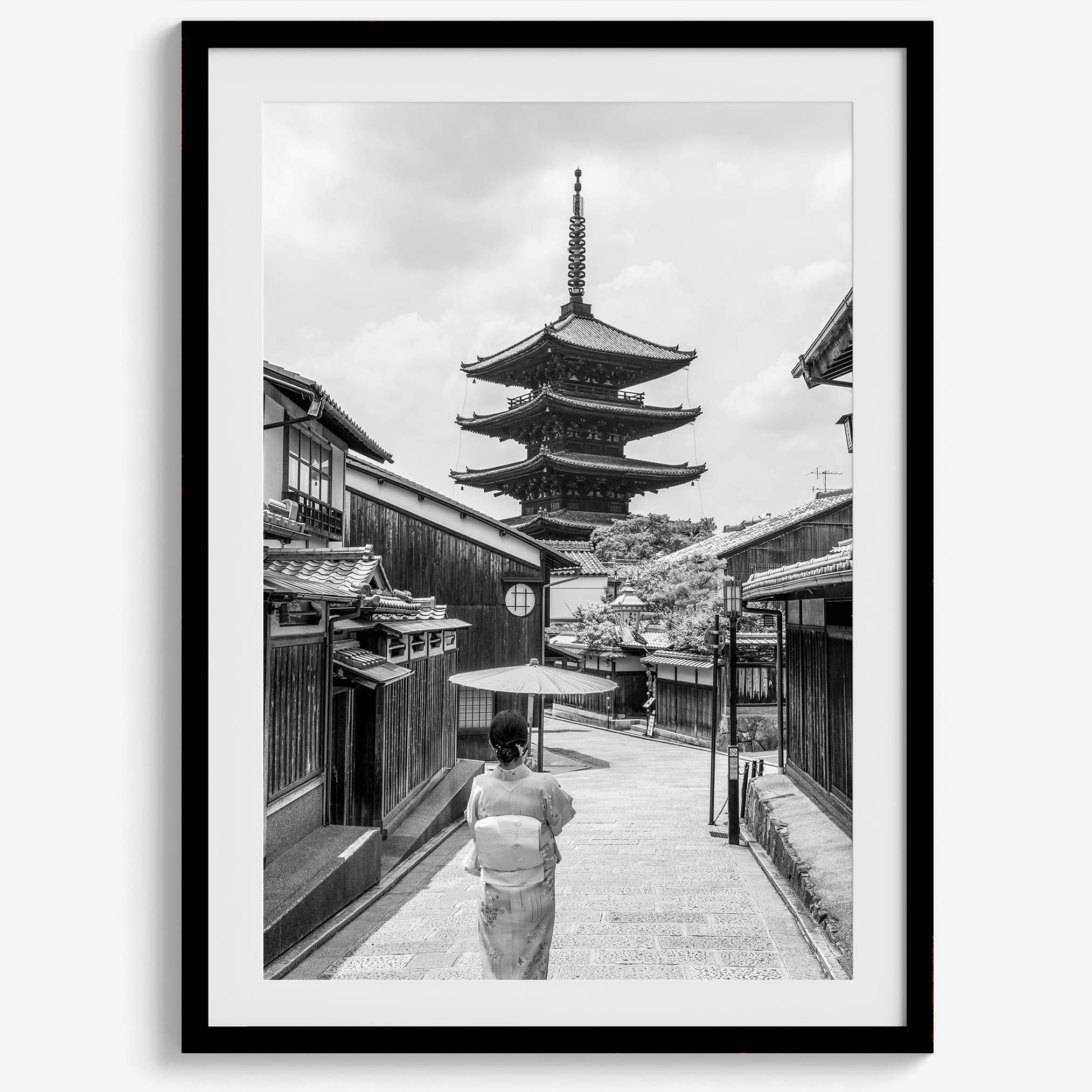 Timeless Kyoto scene with traditional architecture and kimono-clad woman in black and white.