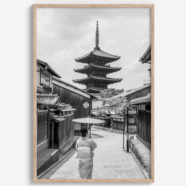 Timeless Kyoto scene with traditional architecture and kimono-clad woman in black and white.