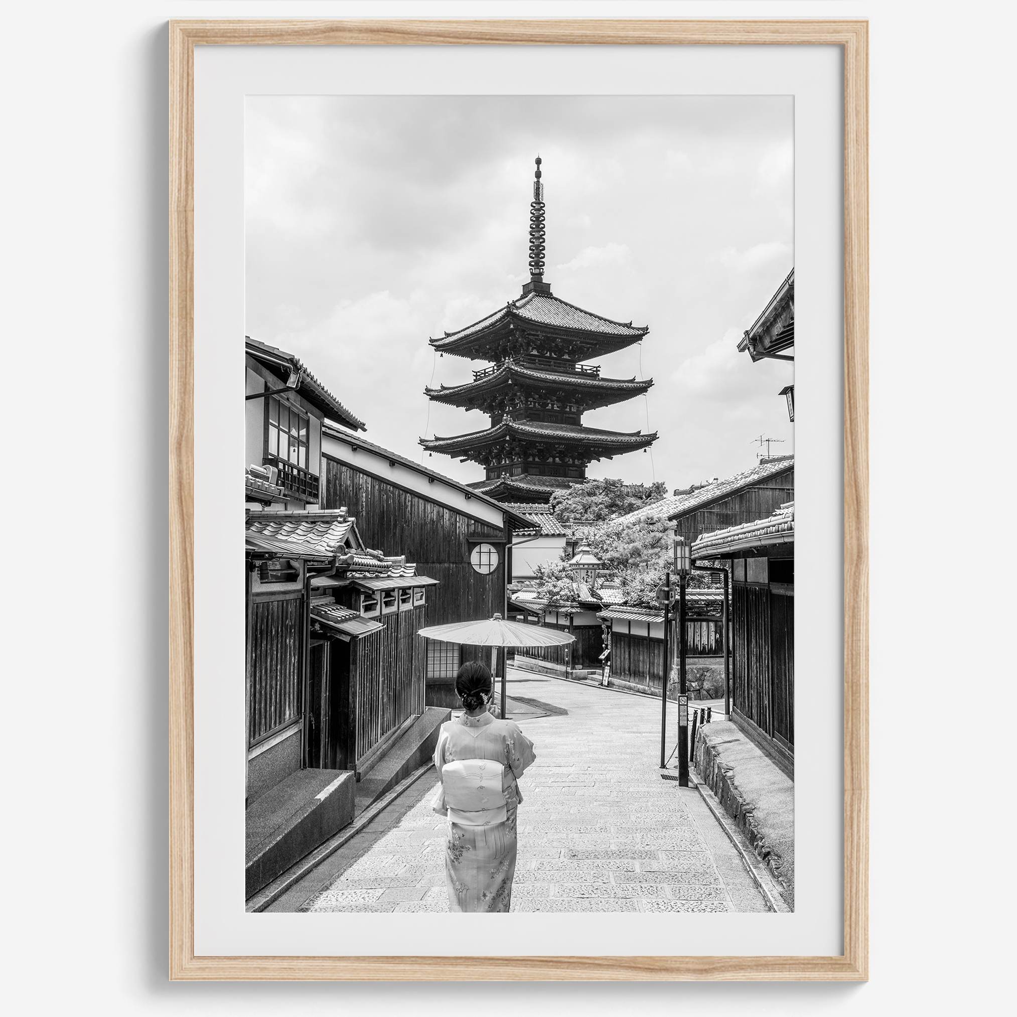 Timeless Kyoto scene with traditional architecture and kimono-clad woman in black and white.