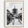 Timeless Kyoto scene with traditional architecture and kimono-clad woman in black and white.