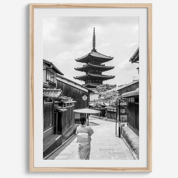 Timeless Kyoto scene with traditional architecture and kimono-clad woman in black and white.