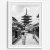 Timeless Kyoto scene with traditional architecture and kimono-clad woman in black and white.