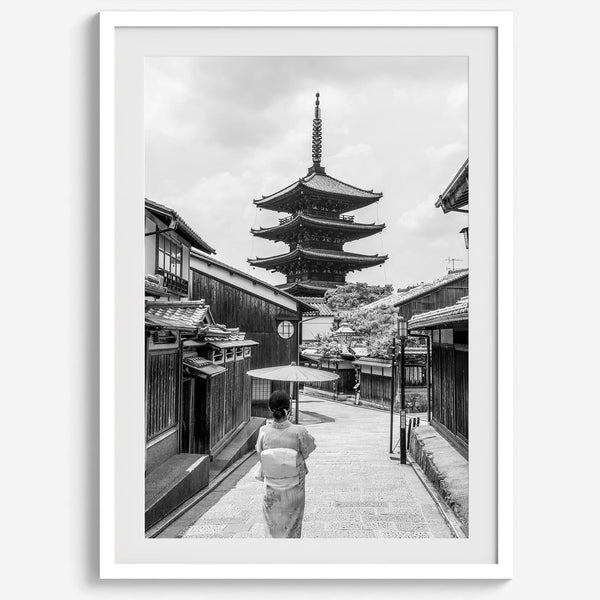 Timeless Kyoto scene with traditional architecture and kimono-clad woman in black and white.