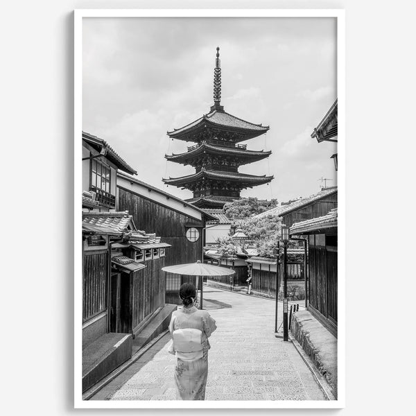 Timeless Kyoto scene with traditional architecture and kimono-clad woman in black and white.