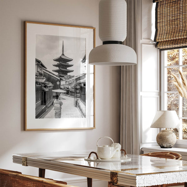 Timeless Kyoto scene with traditional architecture and kimono-clad woman in black and white.
