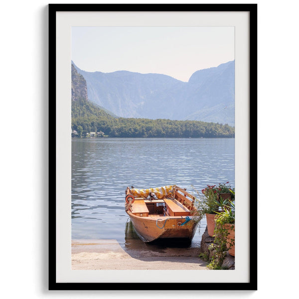 Lake house decor featuring a serene wooden boat on Lake Hallstatt, with mountains and lush greenery, perfect for tranquil spaces.