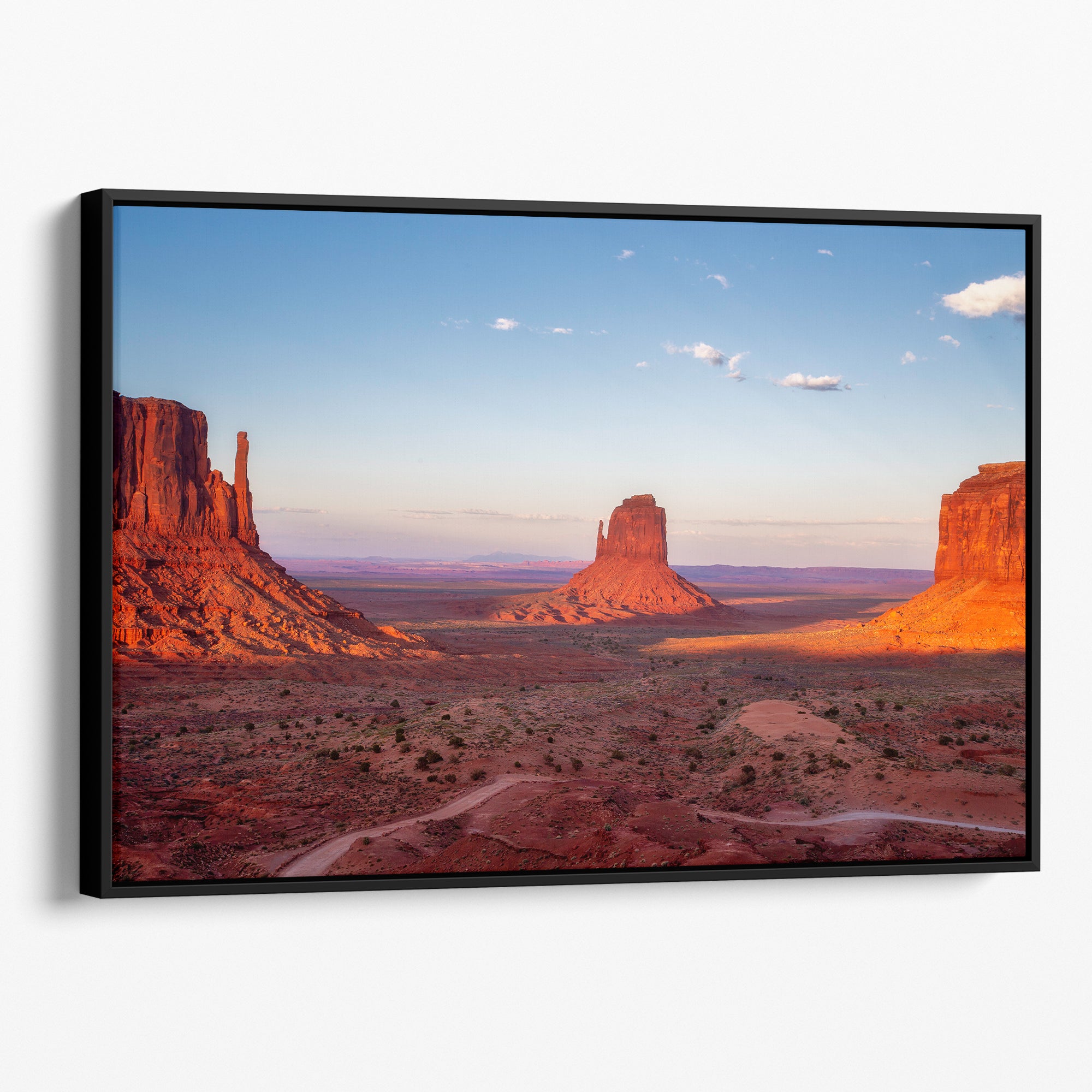 Monument Valley desert landscape print with towering sandstone buttes and a vibrant sunset sky, available as framed or canvas wall art.