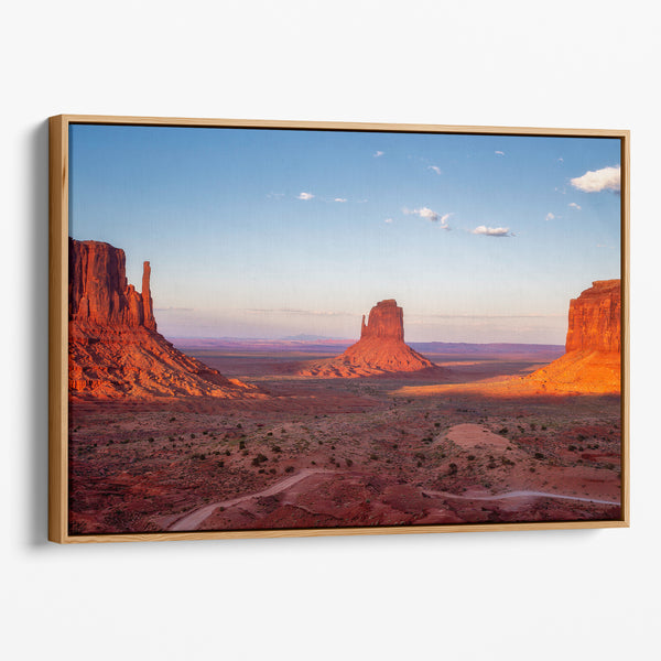 Monument Valley desert landscape print with towering sandstone buttes and a vibrant sunset sky, available as framed or canvas wall art.