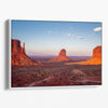 Monument Valley desert landscape print with towering sandstone buttes and a vibrant sunset sky, available as framed or canvas wall art.