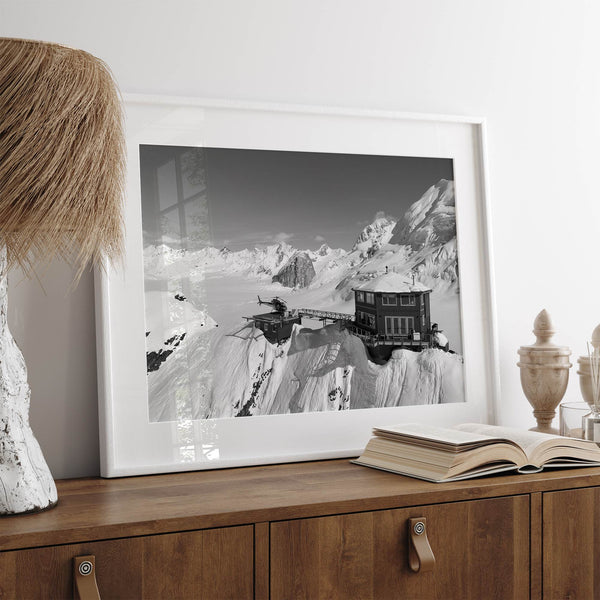 Black and white mountain cabin wall art with helicopter over snowy Denali peaks, Alaska winter landscape photography print.