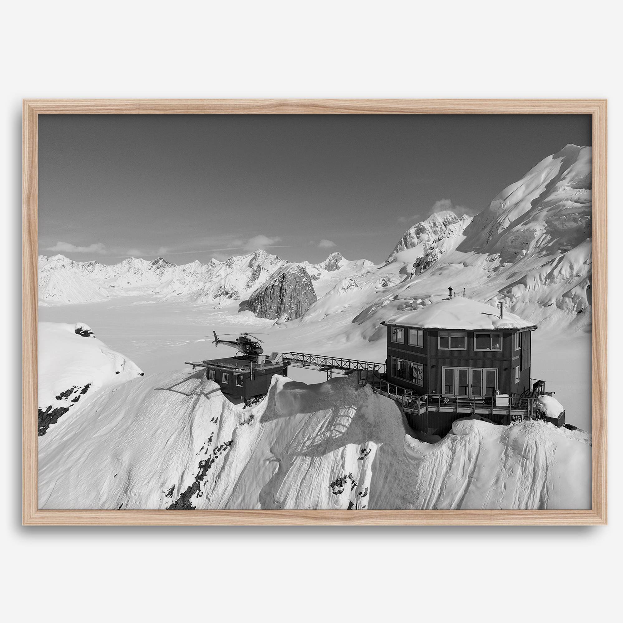 Black and white mountain cabin wall art with helicopter over snowy Denali peaks, Alaska winter landscape photography print.