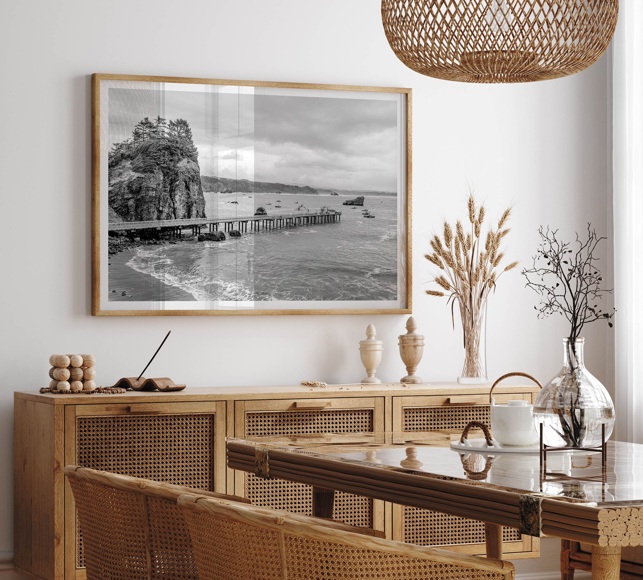 Scenic Pacific Northwest wall art of Trinidad State Park in California in black and white, showcasing a coastal pier, lush green cliffs, and calm ocean waves under cloudy skies.
