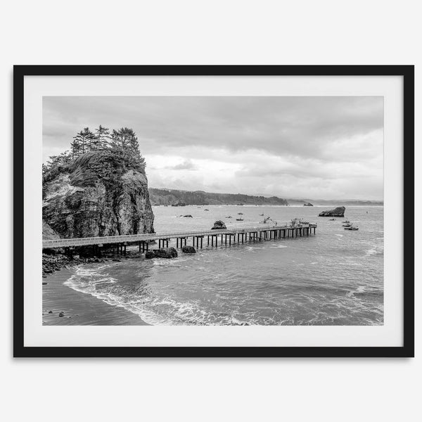 Scenic Pacific Northwest wall art of Trinidad State Park in California in black and white, showcasing a coastal pier, lush green cliffs, and calm ocean waves under cloudy skies.