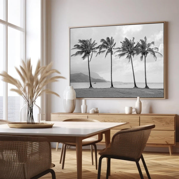 Black and white canvas print of four tall palm trees on Hanalei Bay beach in Kauai, with mountains and cloudy sky in the background.