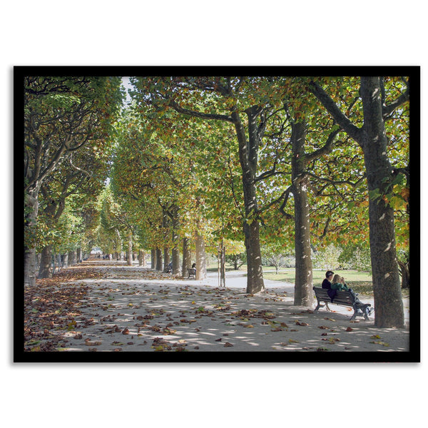 A fine art Paris print of Jardin des Tuileries in fall, featuring a couple sitting on a bench beneath vibrant autumn trees, surrounded by golden foliage.