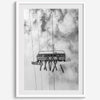 Monochrome ski lift view from below with hanging skis and cloudy mountain sky background.