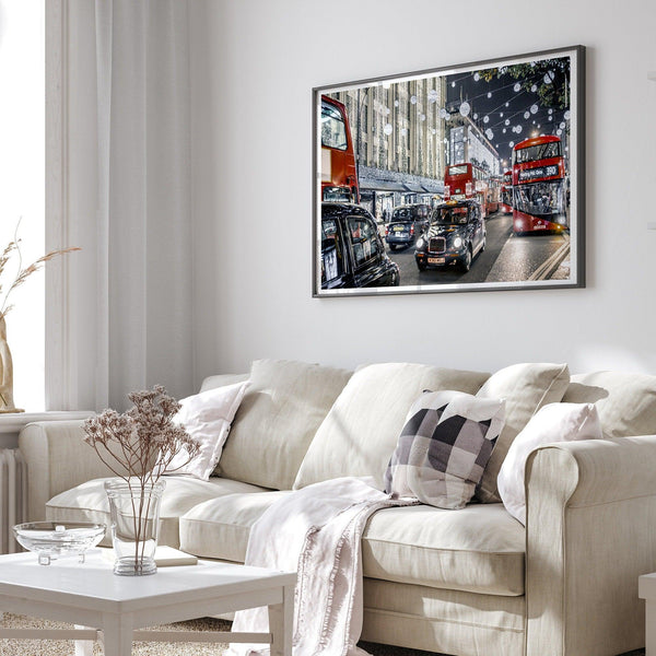 A fine art photography print of a vibrant and lively street in London during the Christmas holidays. This London wall art shows double-decker buses and black taxis, and the streets are adorned with bright holiday lights and festive decorations
