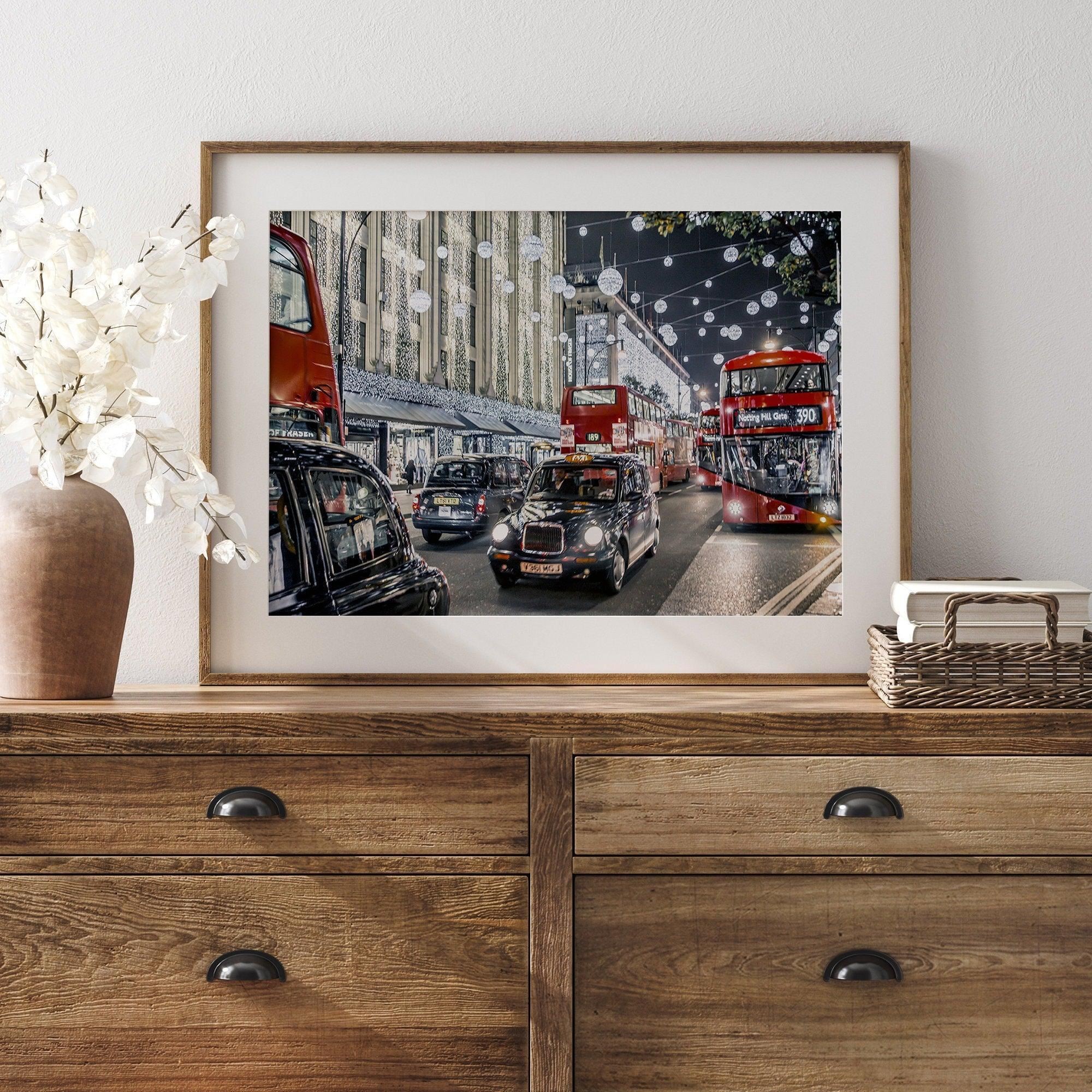 A fine art photography print of a vibrant and lively street in London during the Christmas holidays. This London wall art shows double-decker buses and black taxis, and the streets are adorned with bright holiday lights and festive decorations