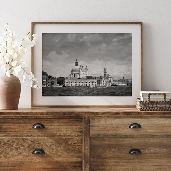 This framed black and white Venice print showcases the iconic Basilica di Santa Maria della Salute and St Mark Square taken from the canal. The clouds add a dramatic effect and create a classic look to this breathtaking Italian wall art.