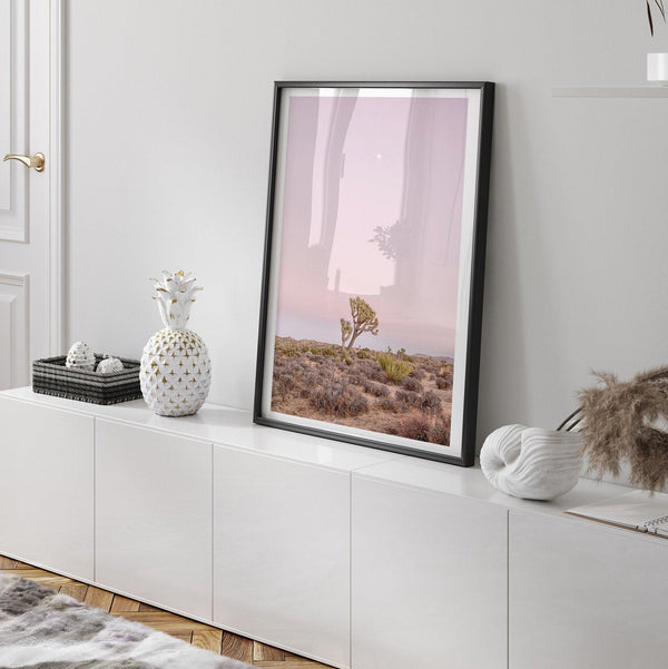 A fine art desert print of a lone Joshua Tree bathing in a pink sunset. This Joshua Tree wall art has a unique composition and portrait orientation.