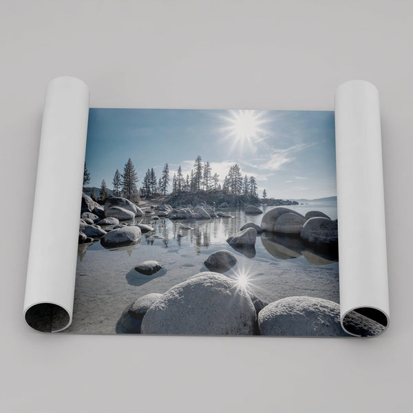 Capture the beauty of Lake Tahoe with this stunning lake wall art. The image showcases majestic rocks rising from crystal-clear water, contrasting with the blue sky. The sun&#39;s reflection adds a warm, magical touch to the breathtaking scenery.