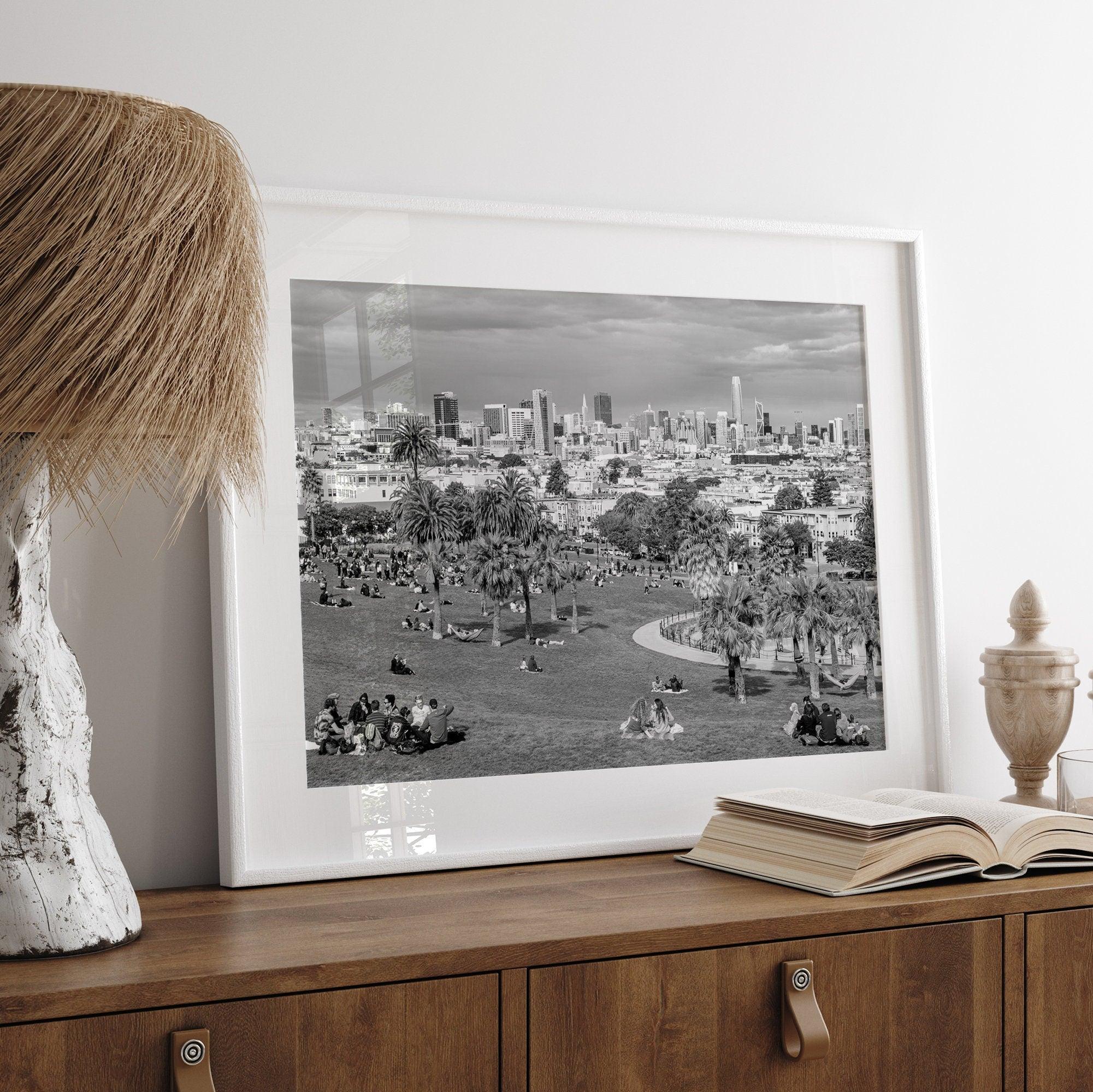 Black and white fine art print of Mission Dolores Park in San Francisco showcasing picnic blankets and people enjoying a quiet afternoon with the city skyline in the backdrop.