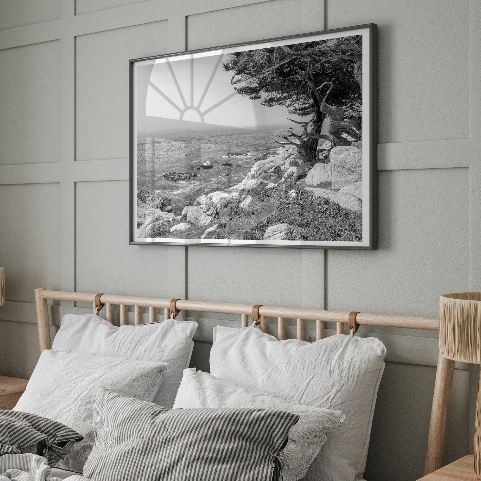 A framed or unframed coastal fine art photography print of a huge cypress tree overlooking the ocean. This black-and-white wall art shows the California rugged coastline in all its glory. Get this Ocean wall decor piece today.