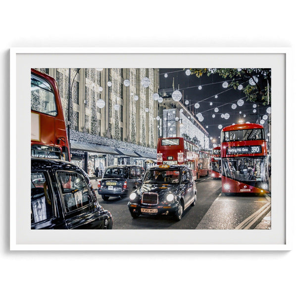 A fine art photography print of a vibrant and lively street in London during the Christmas holidays. This London wall art shows double-decker buses and black taxis, and the streets are adorned with bright holiday lights and festive decorations