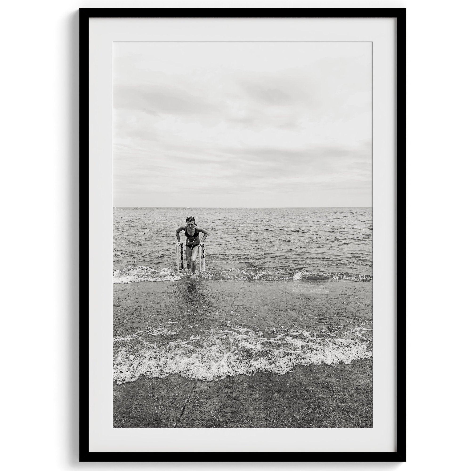 A black and white fine art lake beach print of a beach in Chicago on the coast of Lake Michigan showcasing a woman bathing in the lake. The classic modern look of the print is sure to impress when hung on your walls.