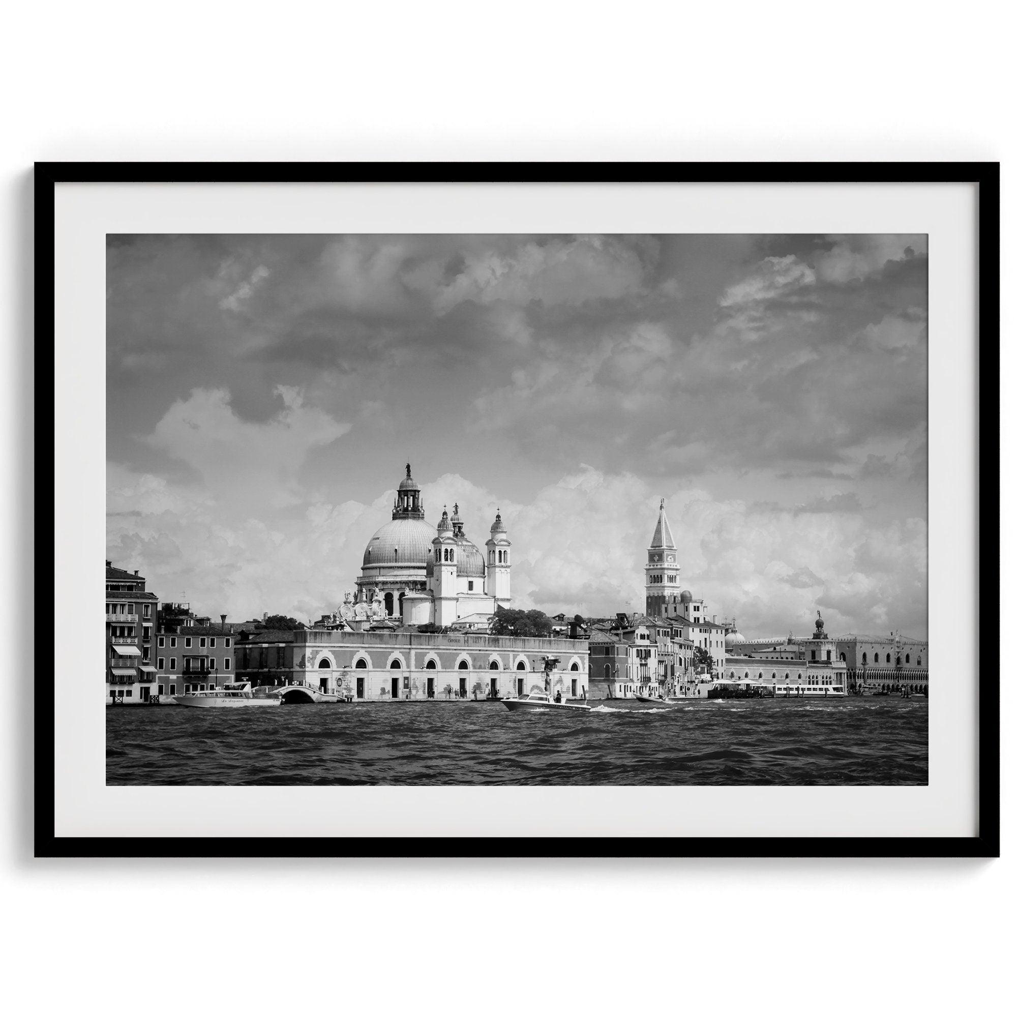 This framed black and white Venice print showcases the iconic Basilica di Santa Maria della Salute and St Mark Square taken from the canal. The clouds add a dramatic effect and create a classic look to this breathtaking Italian wall art.