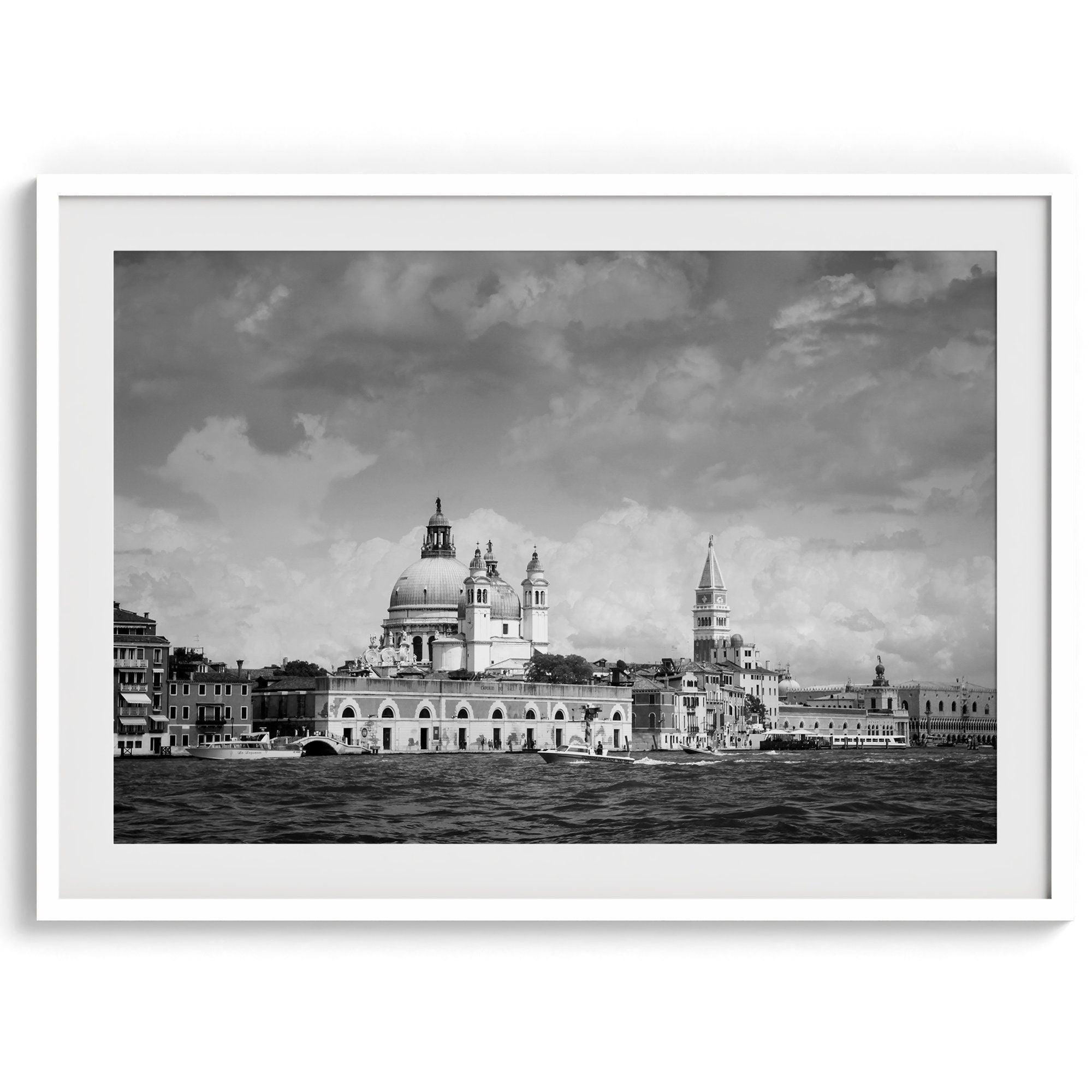 This framed black and white Venice print showcases the iconic Basilica di Santa Maria della Salute and St Mark Square taken from the canal. The clouds add a dramatic effect and create a classic look to this breathtaking Italian wall art.