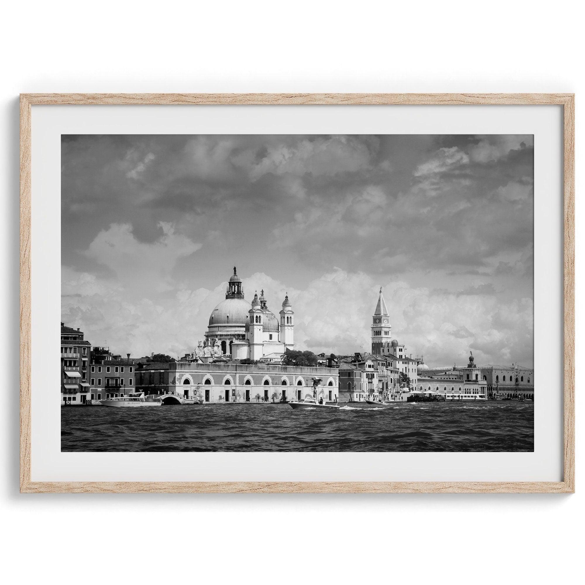 This framed black and white Venice print showcases the iconic Basilica di Santa Maria della Salute and St Mark Square taken from the canal. The clouds add a dramatic effect and create a classic look to this breathtaking Italian wall art.